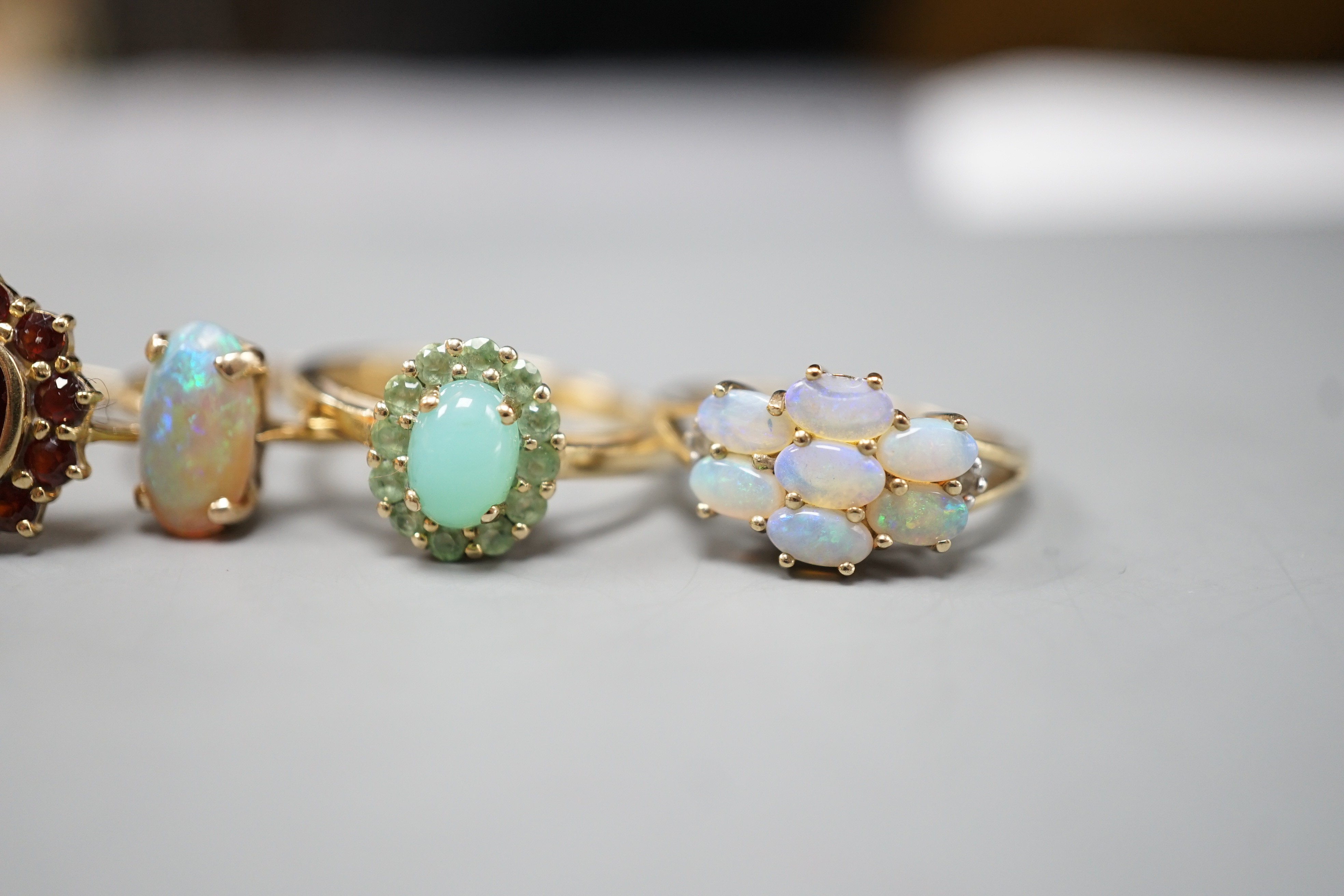 Five assorted modern 9ct gold and gem set dress rings, including white opal and diamond chip cluster, white opal cluster and garnet cluster